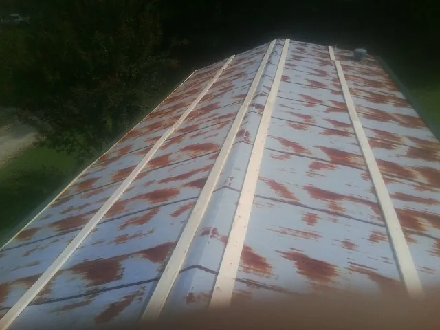Rusted metal roof panels with new wood purlins before replacement — Storm Damage Roof Repair in Absarokee by Roofing Brothers