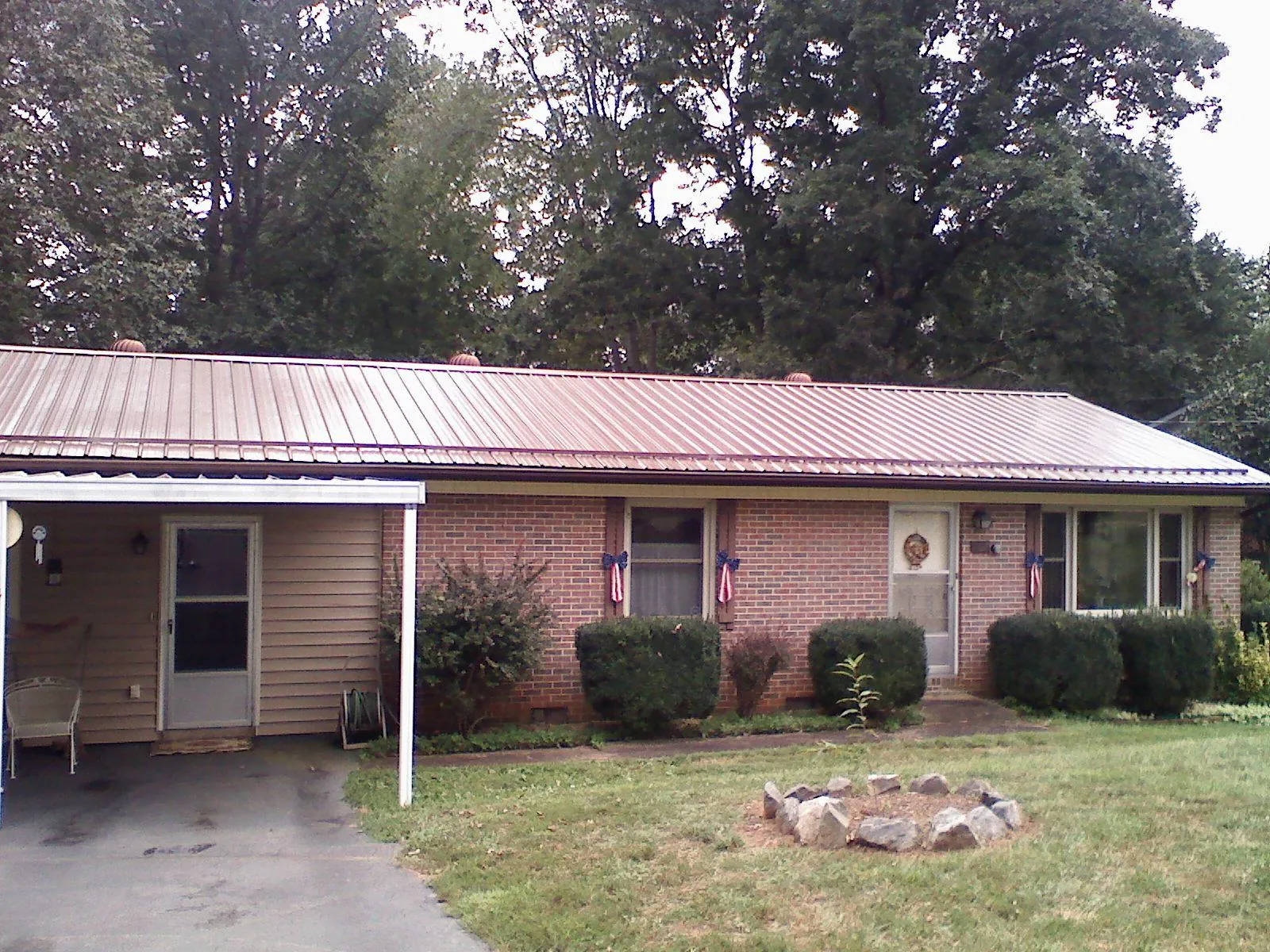 Bronze metal roof and carport on a brick ranch home — Roof Repair work by our crew in Absarokee